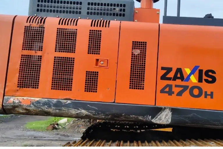 Close-up of the orange side housing and model decal of a Hitachi Zaxis 470H heavy-duty excavator.