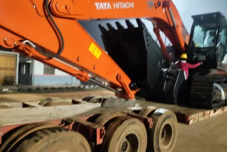 A Tata Hitachi Zaxis 400 MTH Quarry excavator being loaded onto a low-bed trailer at night.