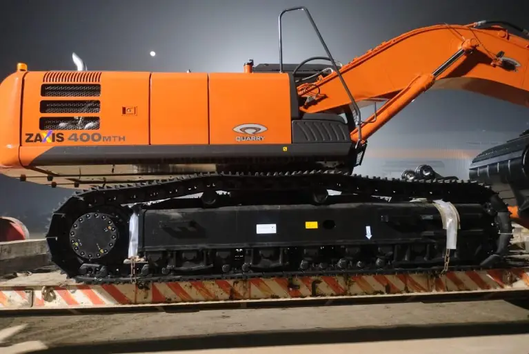 Side view of the heavy-duty MTH undercarriage and tracks of a Tata Hitachi Zaxis 400 MTH Quarry excavator.